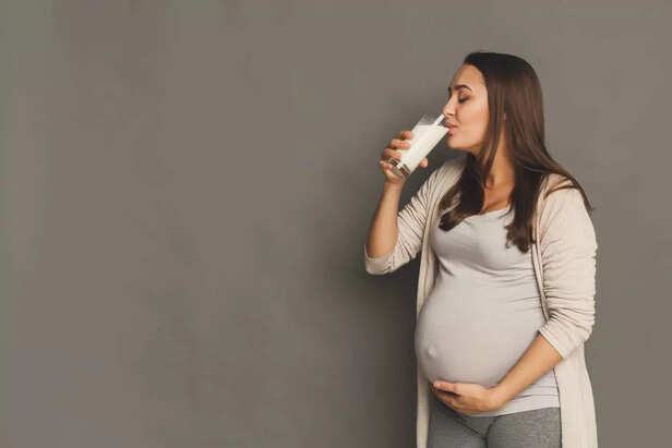 Pregnant woman drinking glass of milk