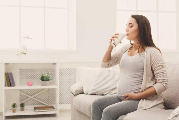 Pregnant woman drinking glass of milk